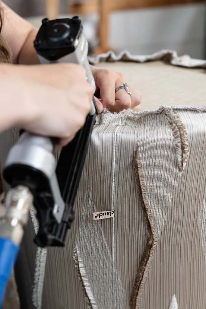 Vakmanschap in het Claudi-atelier: nietpistool op bekleding met Claudi-label